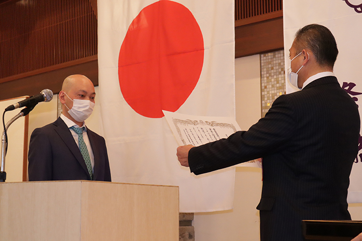 佐藤章寿名誉会長(右)から表彰を受ける金光さん