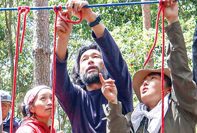萩原さん（中央）からロープの結び方を教わる参加者（撮影・山北）