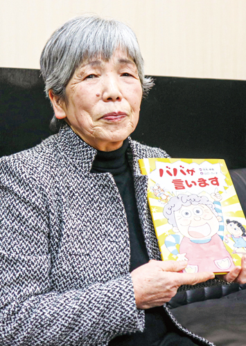 絵本を手に、作品への思いを語る宮丸さん(撮影・山北)