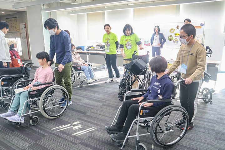 車椅子体験をする参加者ら